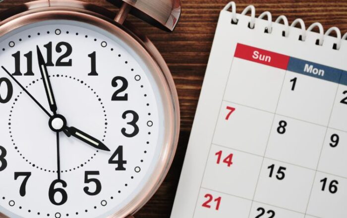 Modern office desk setup with a detailed calendar displaying all 31 days, a laptop showing compliance documents, and organized 1095-C forms, symbolizing ACA reporting preparation and accuracy.